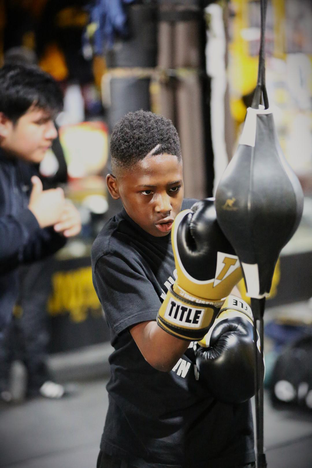 Young boxer training on a speed bag with Title gloves